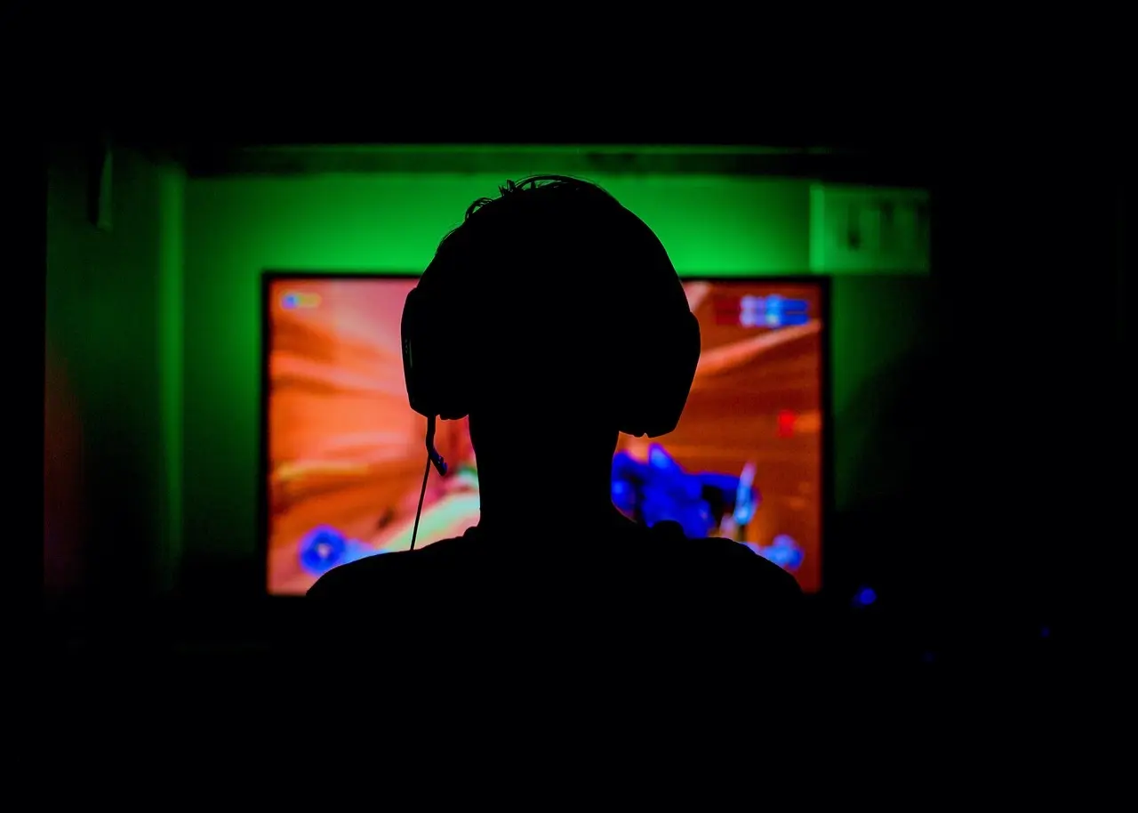 Silhuet af gamer med headset foran skærm
